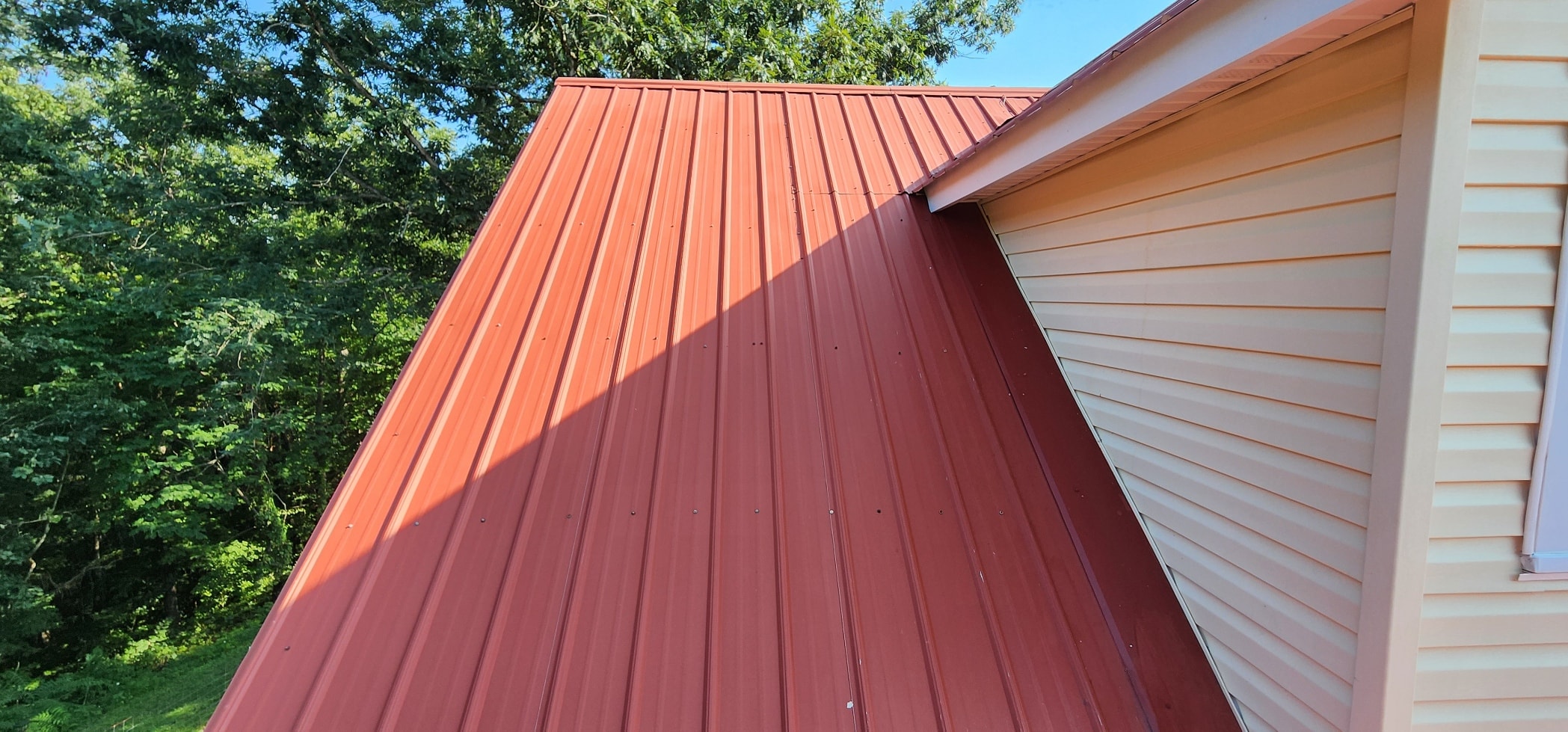 Modern house red metal roof exterior clean after soft wash